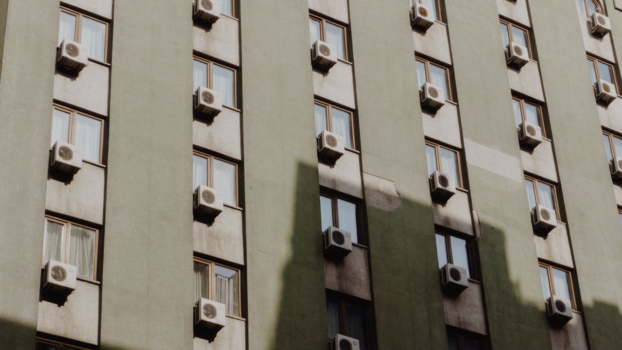 Fachada de edificio con unidades exteriores de aire acondicionado junto a ventanas