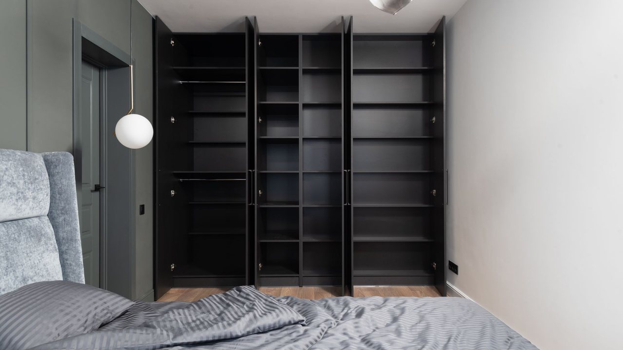 Bedroom with dark open wardrobe frames