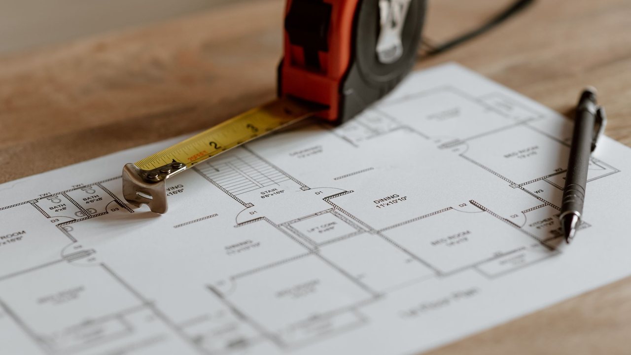 Tape measure and pencil on a house plan