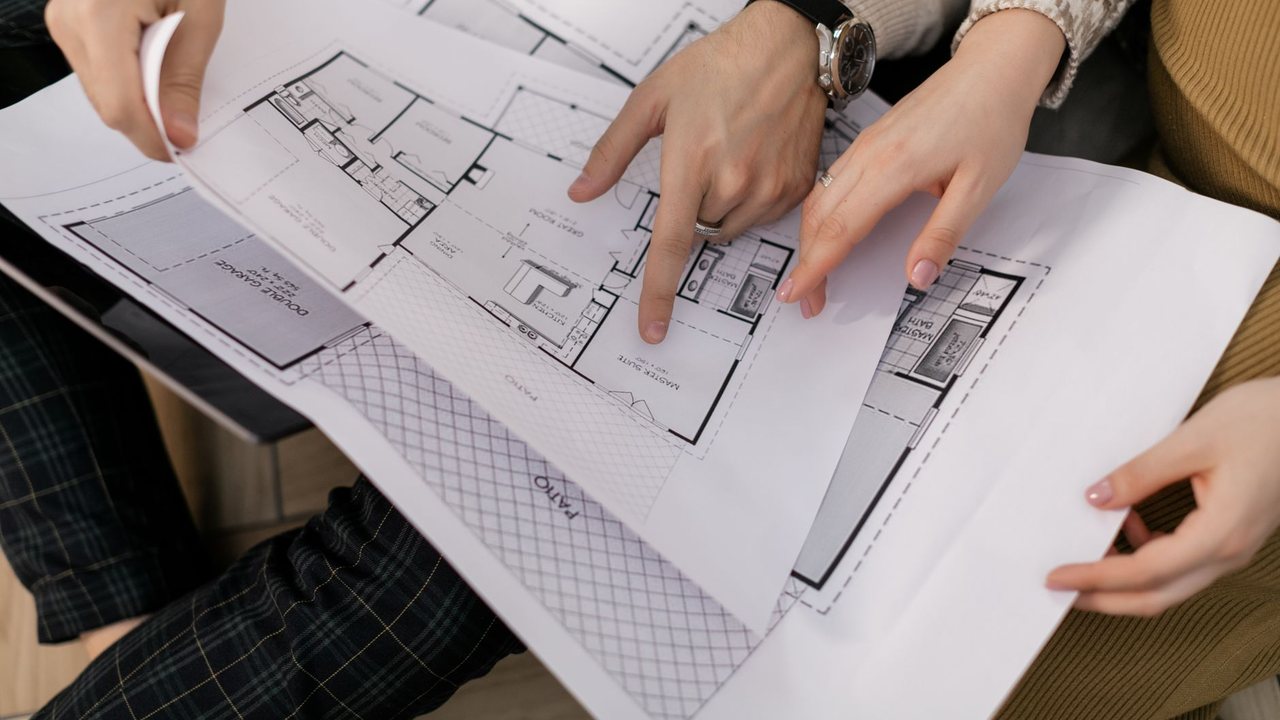 Manos señalando estancias en un plano de vivienda