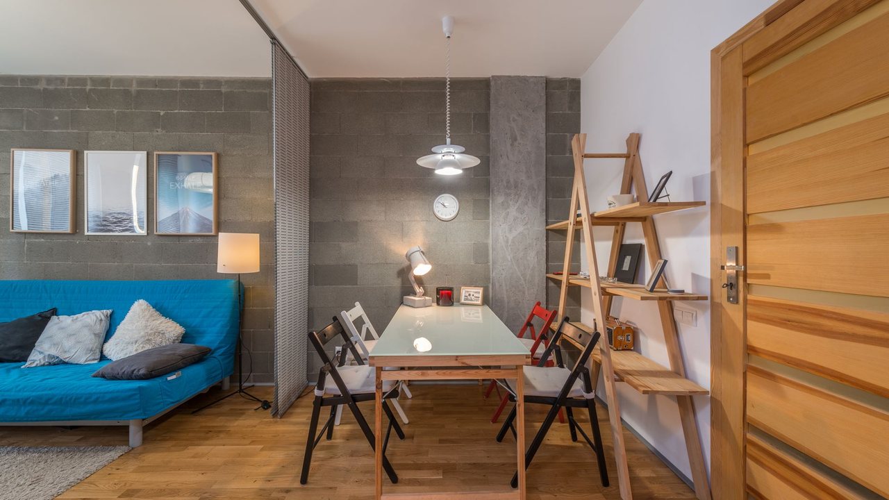 Salón comedor con lámpara colgante sobre la mesa y luz junto al sofá