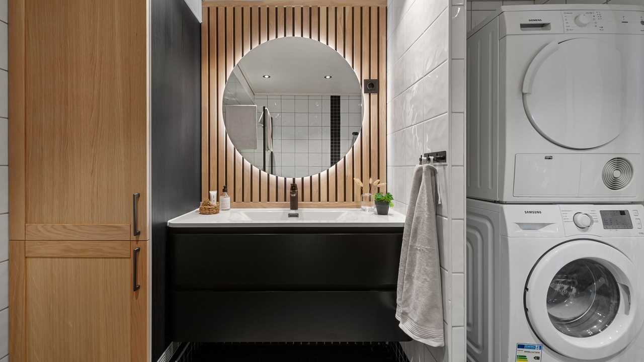 Baño con lavabo y lavadora y secadora en columna