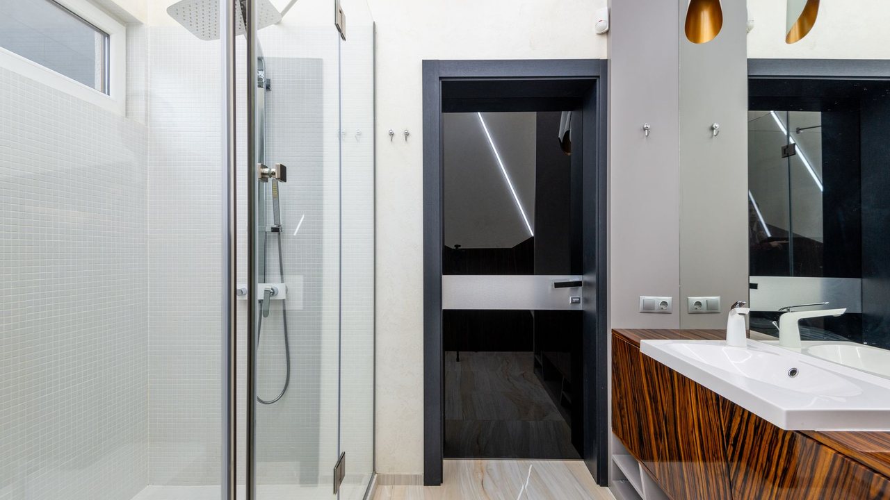 Bathroom with a glass shower enclosure beside the vanity