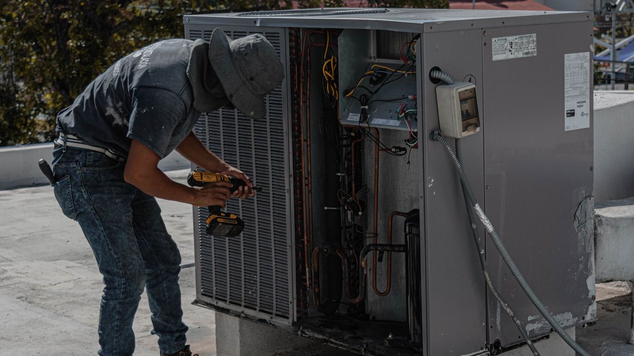 Técnico trabajando junto a equipos exteriores de climatización
