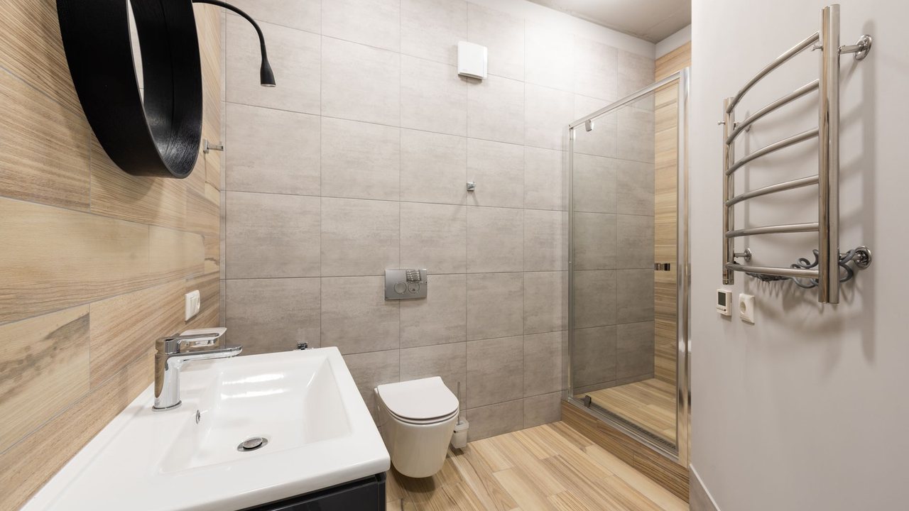 Baño alicatado con lavabo, inodoro y ducha al fondo
