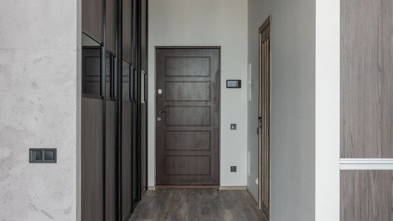 Apartment corridor with a wooden door and wardrobe