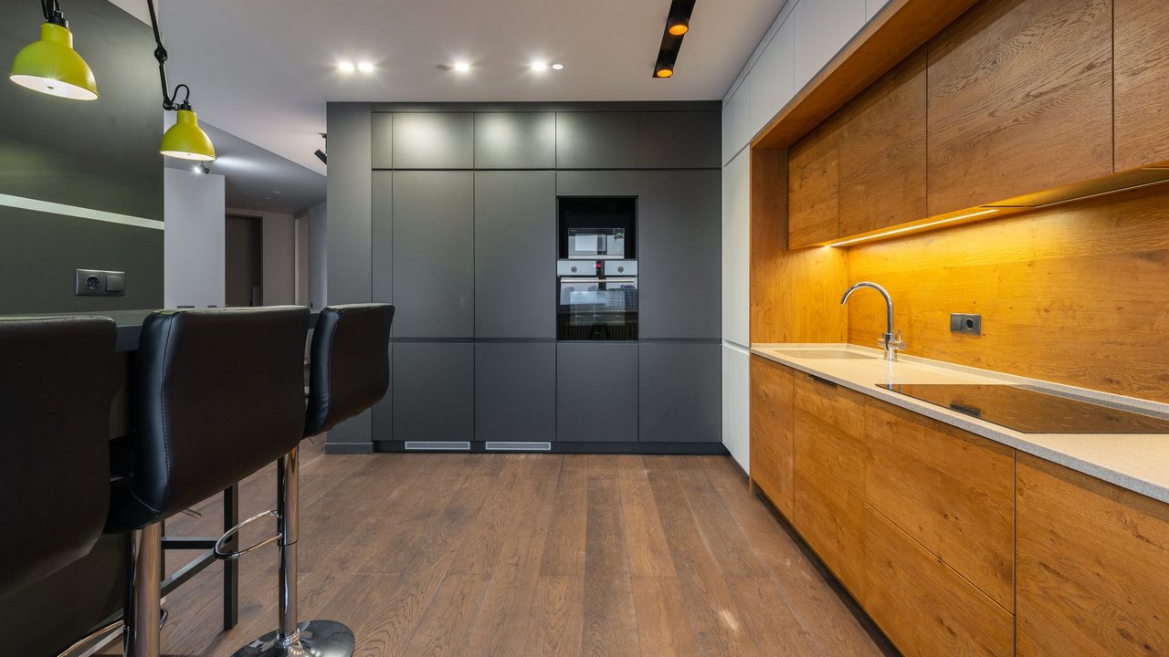 Cocina con frentes de madera y oscuros sobre suelo de aspecto madera